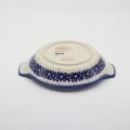 Round baking dish with handles made of Boleslawiec pottery.