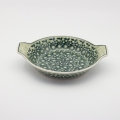 Round baking dish with handles made of Boleslawiec pottery.
