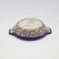 Round baking dish with handles made of Boleslawiec pottery.
