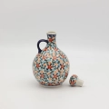 Hand-painted round decanter made from traditional Bolesławiec pottery. Unique ceramic bottle perfect for serving liqueurs, water, or as a table decoration.