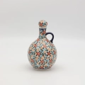 Hand-painted round decanter made from traditional Bolesławiec pottery. Unique ceramic bottle perfect for serving liqueurs, water, or as a table decoration.