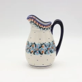 Handmade Bolesławiec ceramic pitcher featuring traditional Polish pottery stamp patterns.