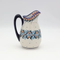 Handmade Bolesławiec ceramic pitcher featuring traditional Polish pottery stamp patterns.