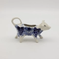Traditional Bolesławiec stoneware creamer with an ergonomic handle and pour spout.