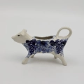 Traditional Bolesławiec stoneware creamer with an ergonomic handle and pour spout.