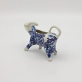 Traditional Bolesławiec stoneware creamer with an ergonomic handle and pour spout.