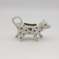 Traditional Bolesławiec stoneware creamer with an ergonomic handle and pour spout.