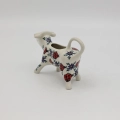 Traditional Bolesławiec stoneware creamer with an ergonomic handle and pour spout.