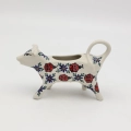Traditional Bolesławiec stoneware creamer with an ergonomic handle and pour spout.