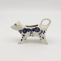 Traditional Bolesławiec stoneware creamer with an ergonomic handle and pour spout.