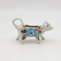 Traditional Bolesławiec stoneware creamer with an ergonomic handle and pour spout.