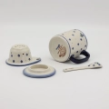 Handcrafted Bolesławiec ceramic tea mug with infuser and lid, traditional hand-painted pattern.