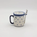 Handcrafted Bolesławiec ceramic tea mug with infuser and lid, traditional hand-painted pattern.