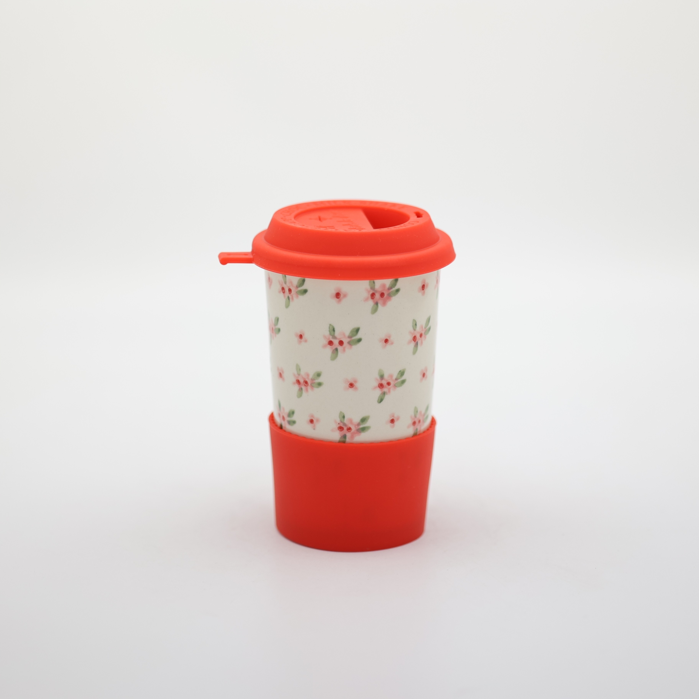 Handmade Bolesławiec ceramic travel mug with silicone lid featuring traditional Polish pottery patterns.