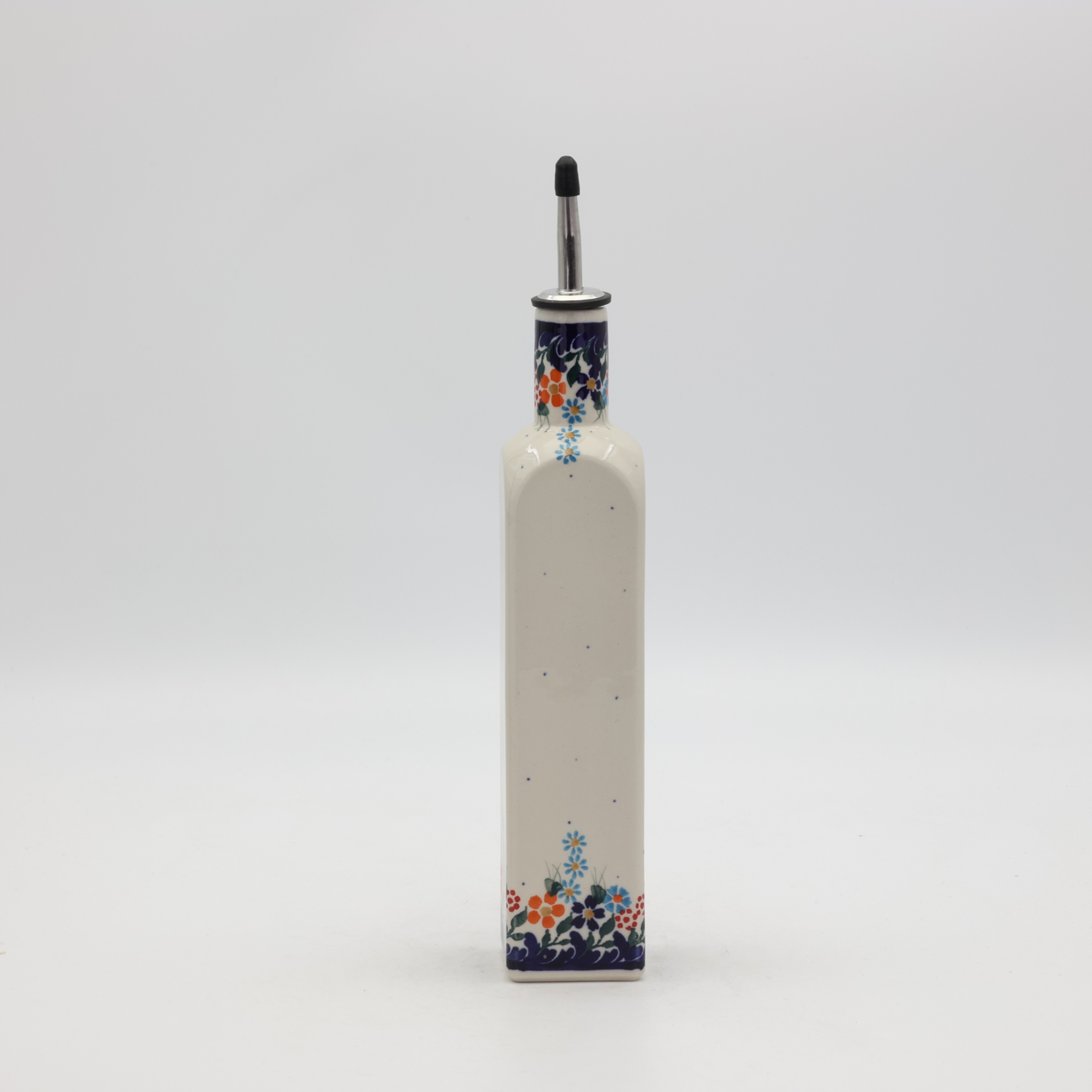 Handcrafted Bolesławiec ceramic bottle with red tomato pattern.