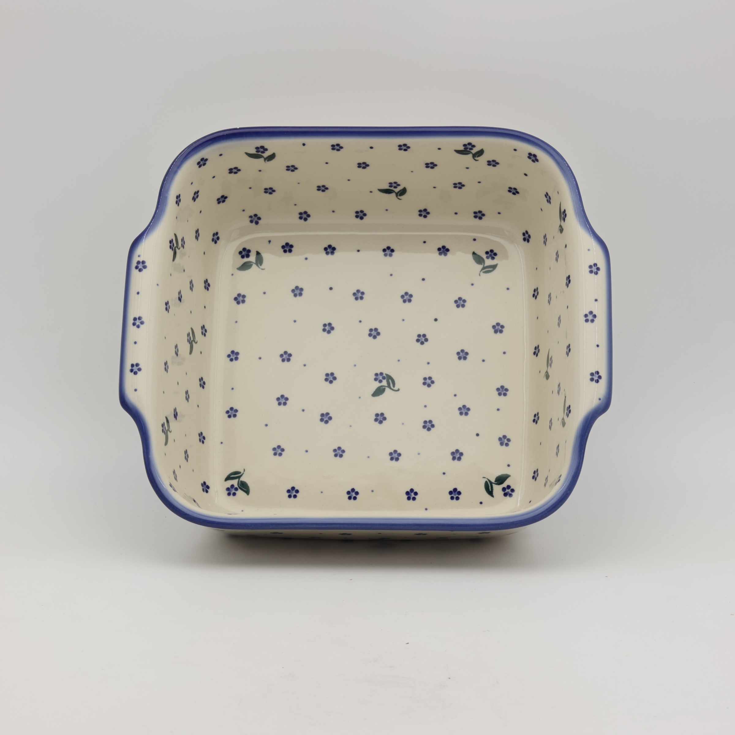 Handcrafted Bolesławiec ceramic baking dish with handles.