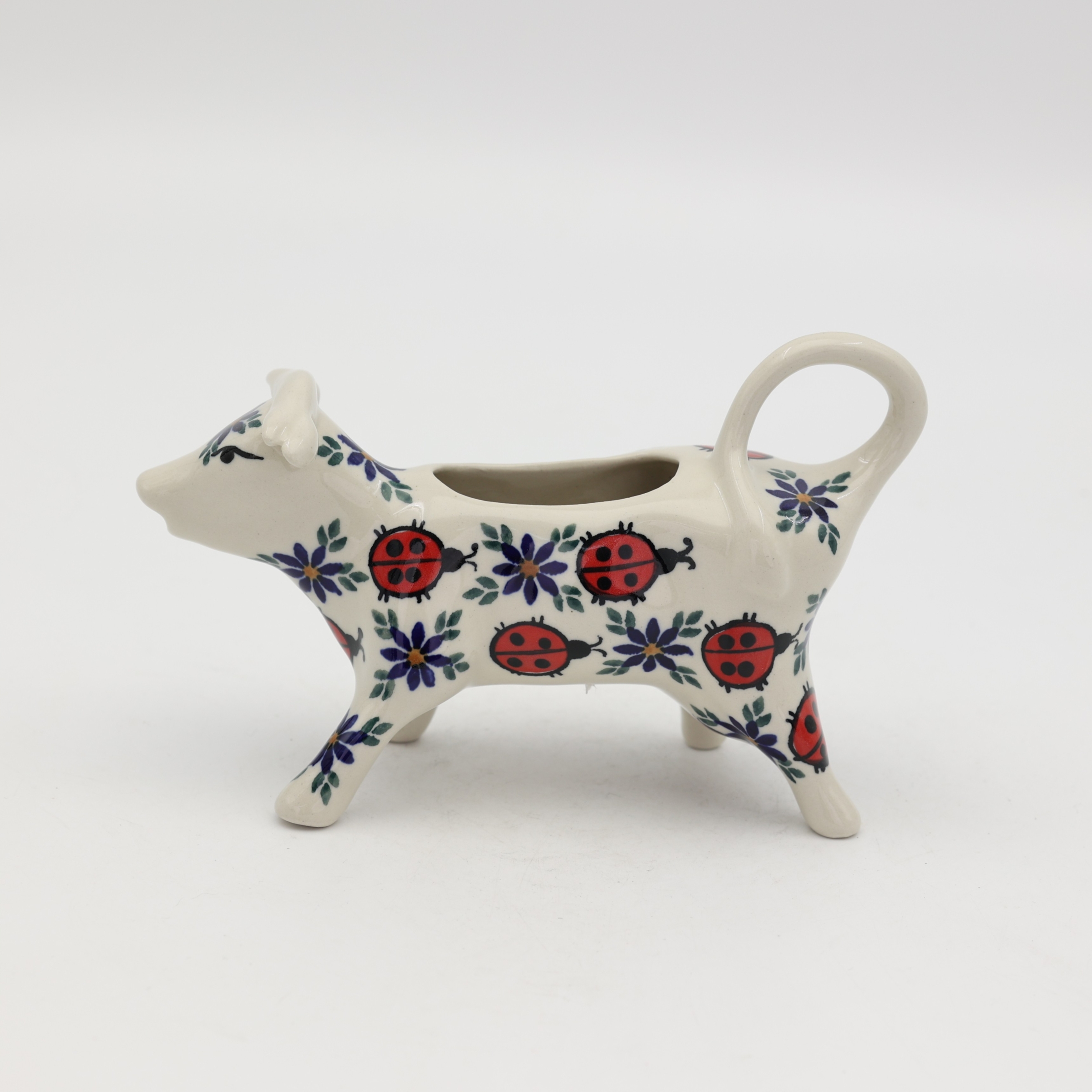 Traditional Bolesławiec stoneware creamer with an ergonomic handle and pour spout.