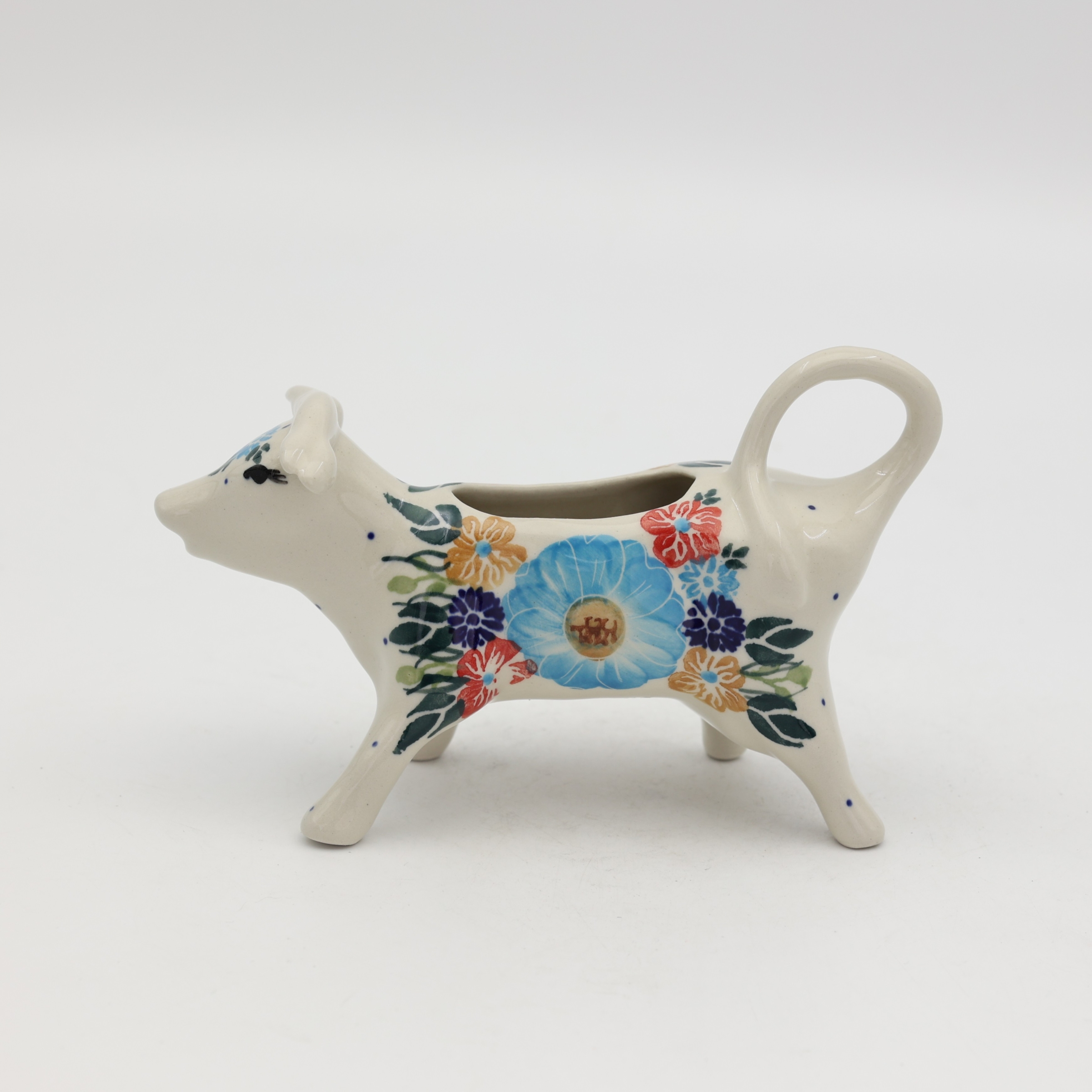 Traditional Bolesławiec stoneware creamer with an ergonomic handle and pour spout.