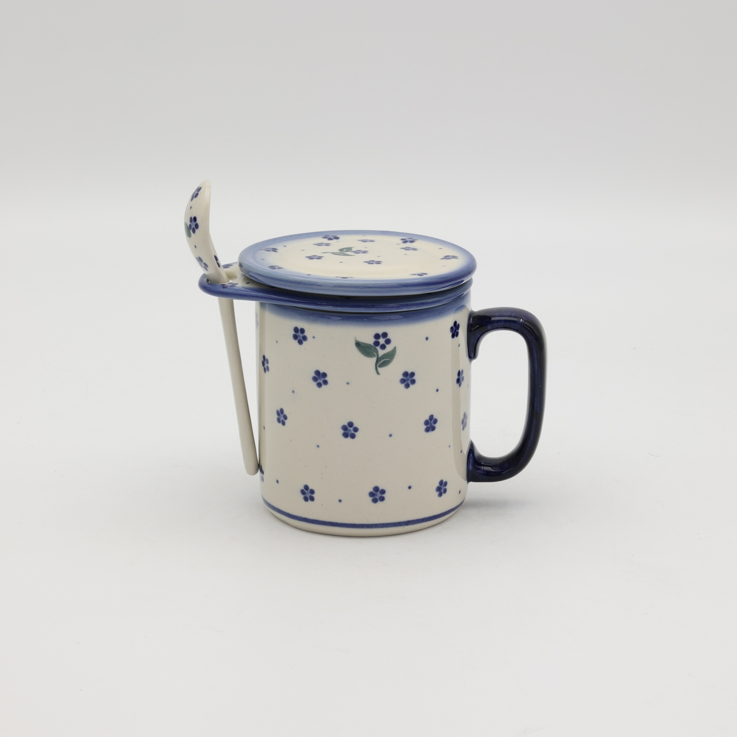 Handcrafted Bolesławiec ceramic tea mug with infuser and lid, traditional hand-painted pattern.